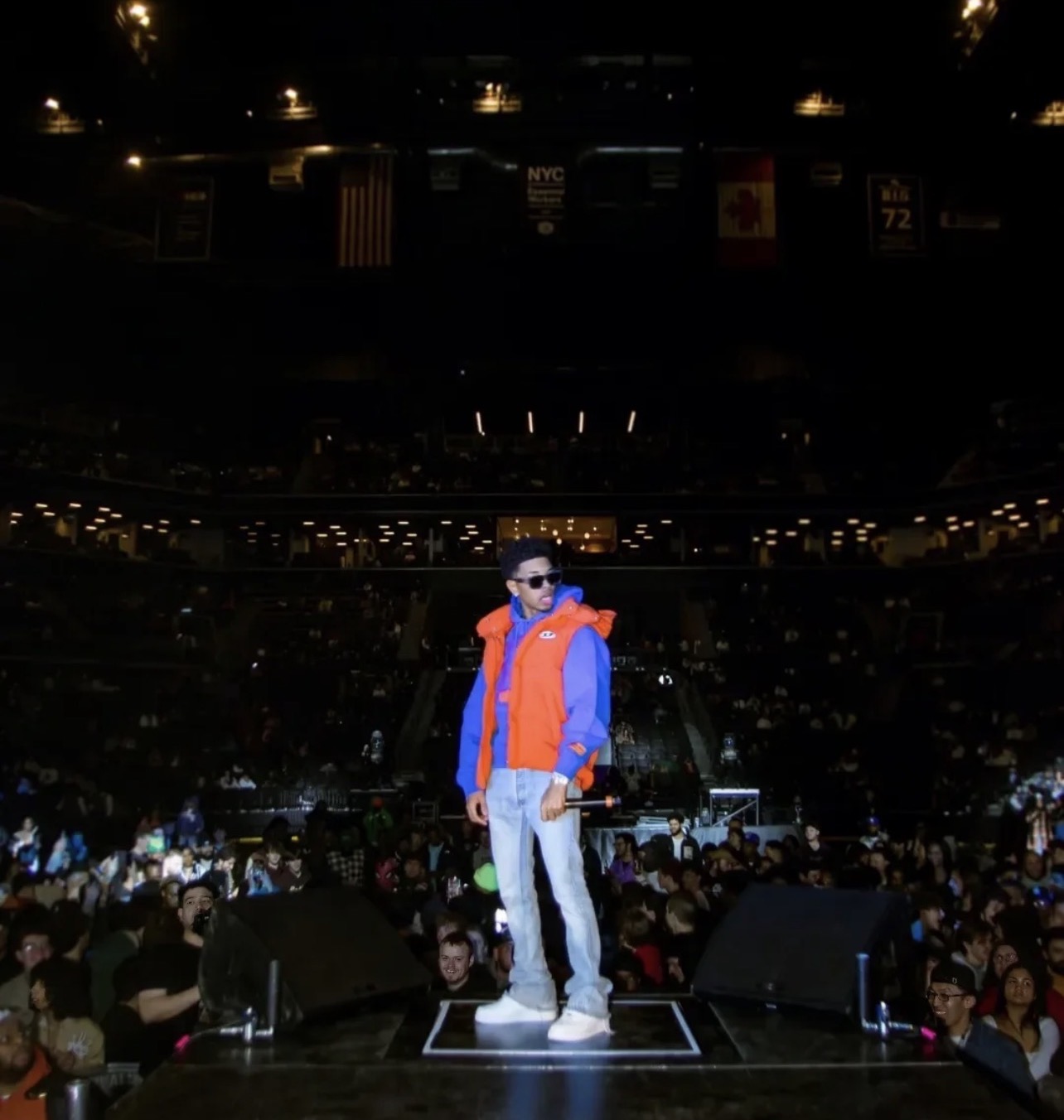 CJ WestCoast standing on a platform over a packed arena crowd