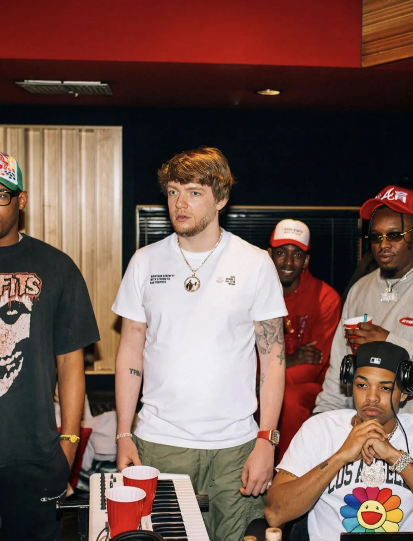 CJ WestCoast with headphones on, in the studio with his production crew